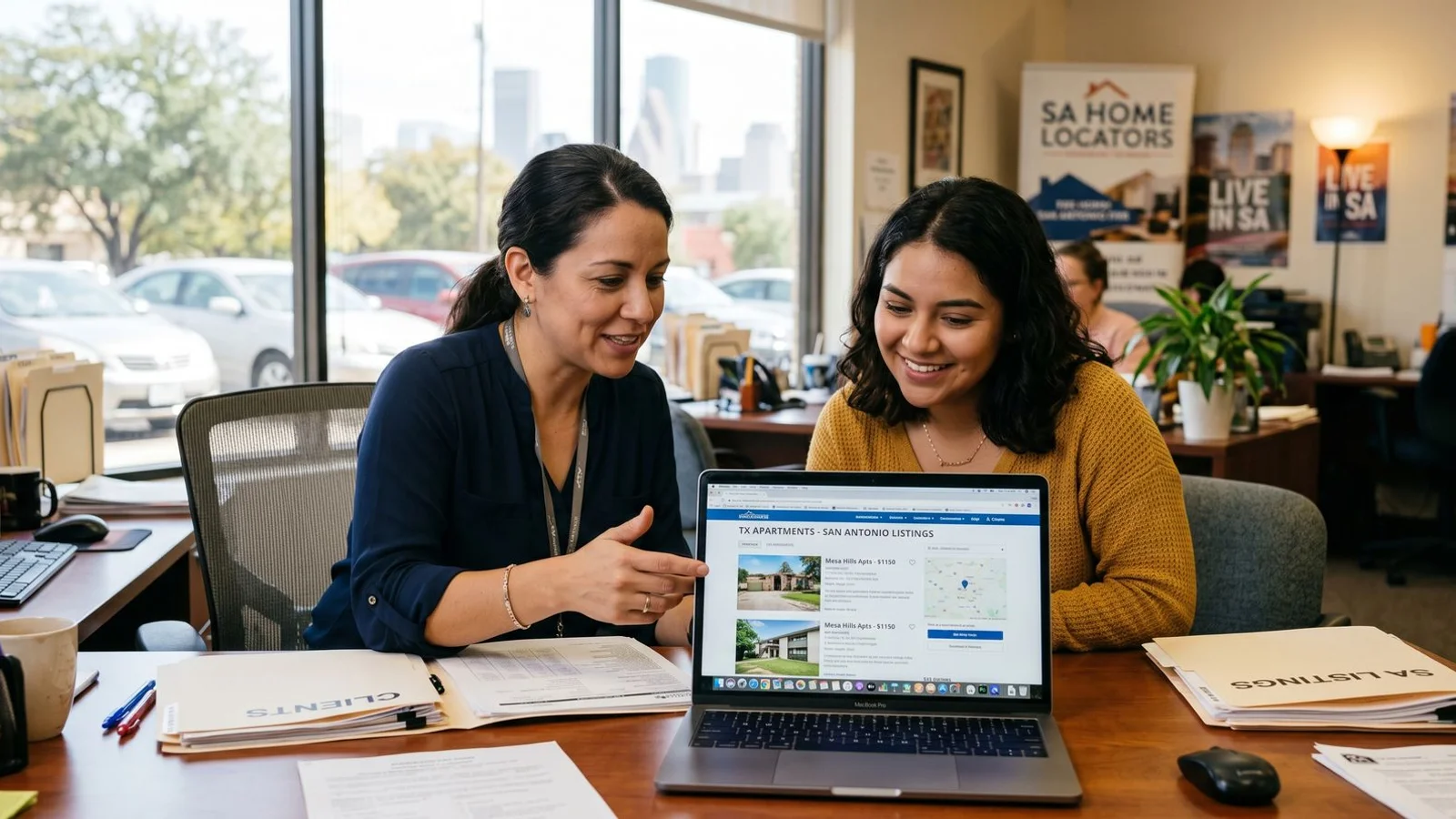 Apartment locator reviewing listings with a renter at a desk in San Antonio