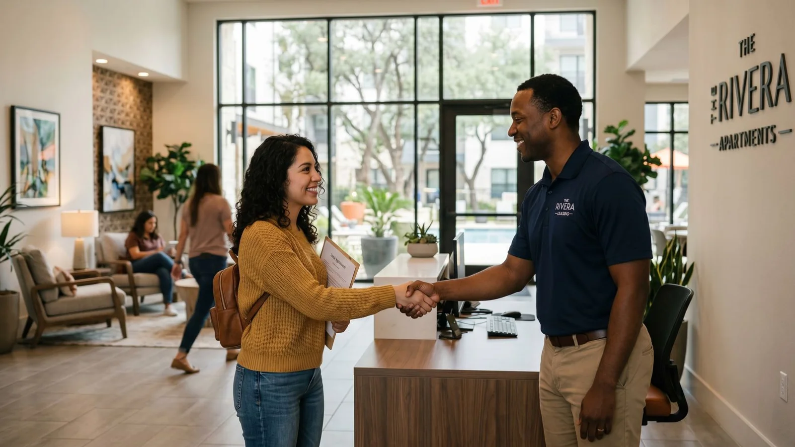 Friendly leasing-office handshake in a San Antonio apartment community lobby